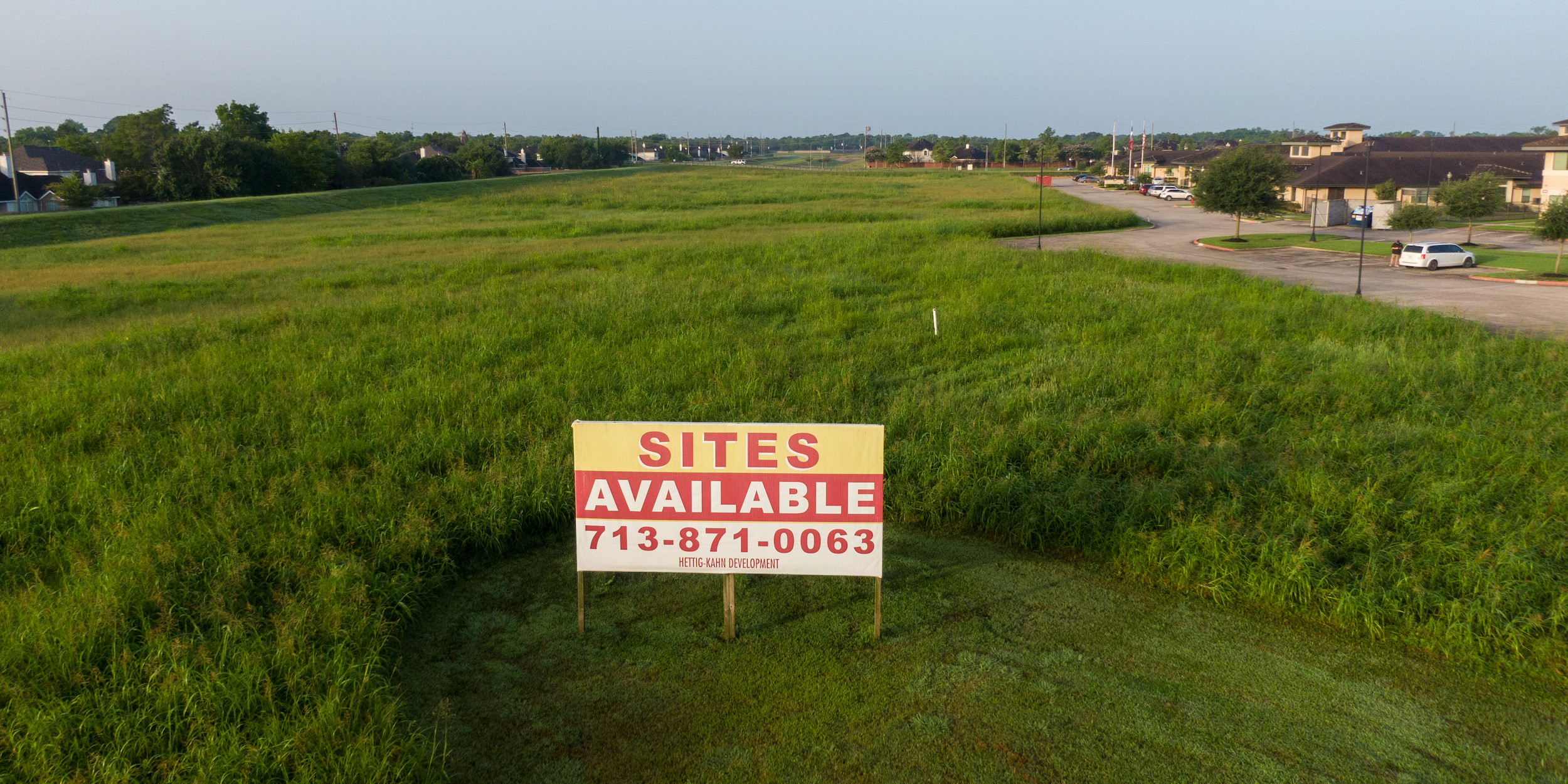 Photo of empty lot with "sites available" sign