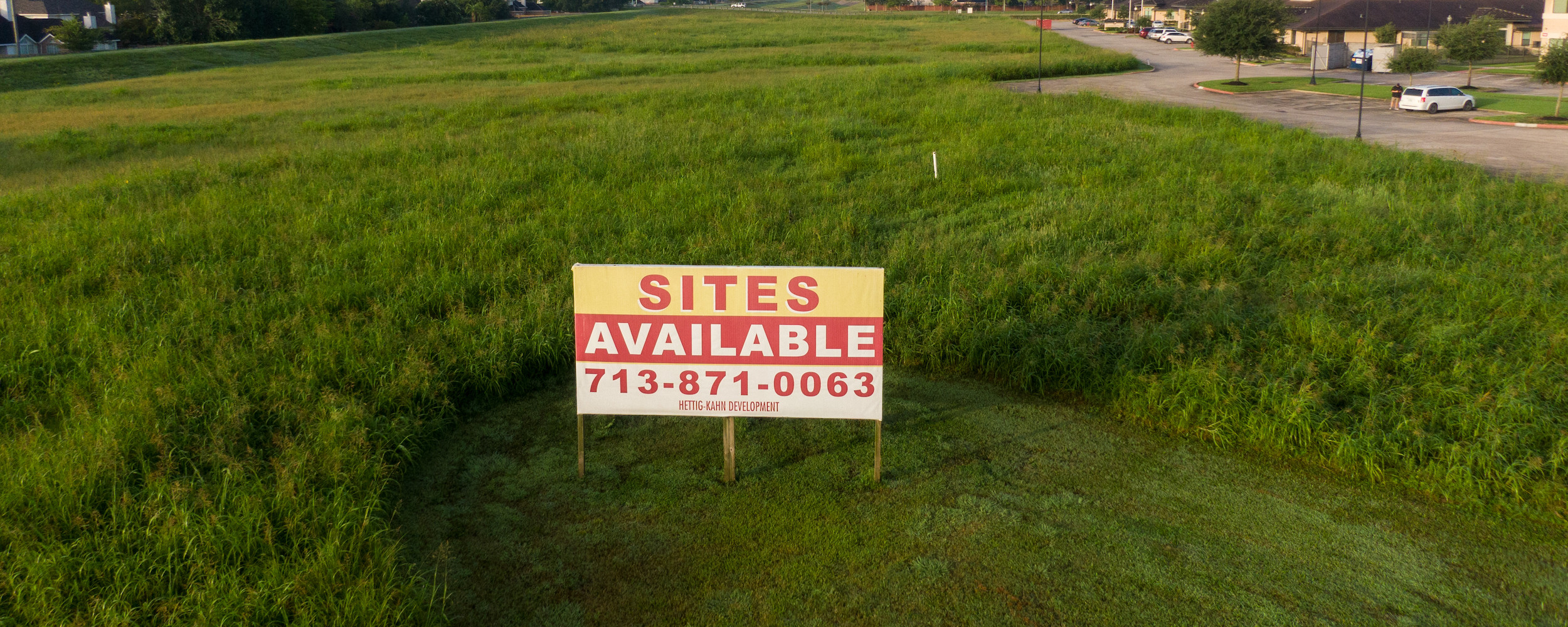 Photo of empty lot with "sites available" sign