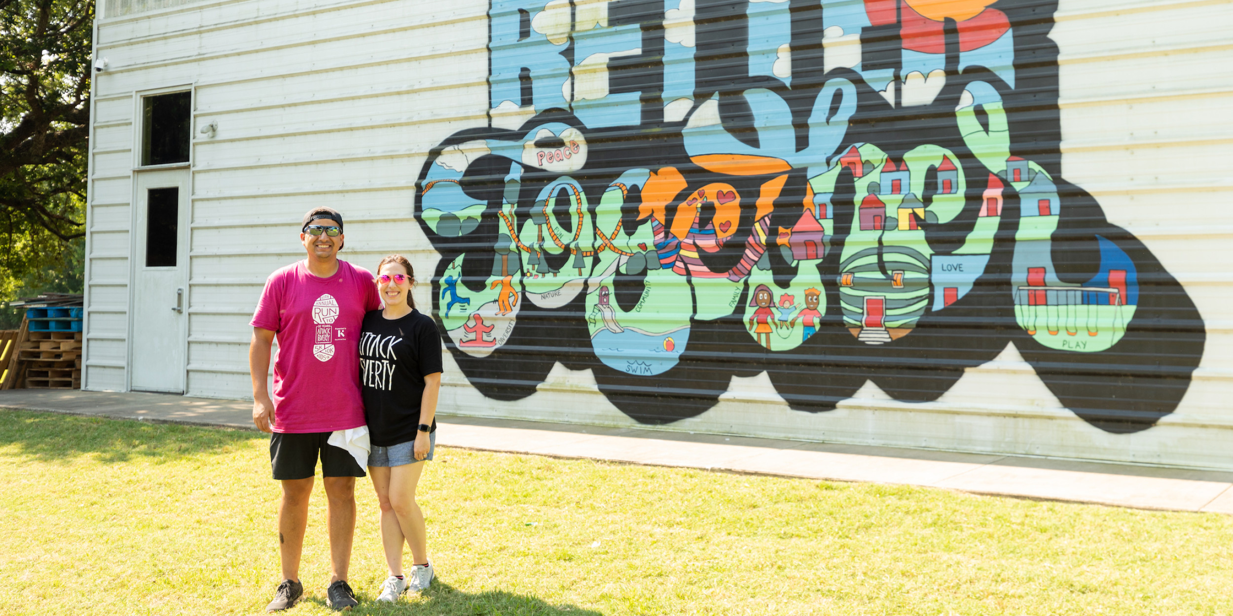 Couple standing in front of a painted mural that reads "Better Together"